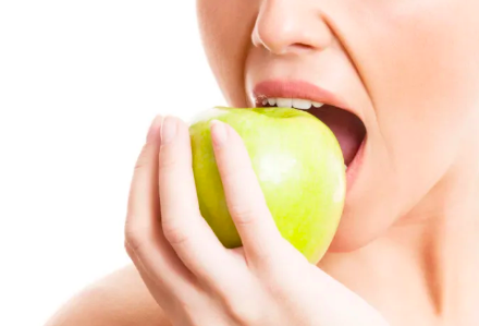 a girl biting an apple